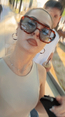 Woman tries sunglasses near street art in Bulgarian city