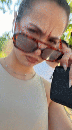 Woman tries sunglasses near street art in Bulgarian city