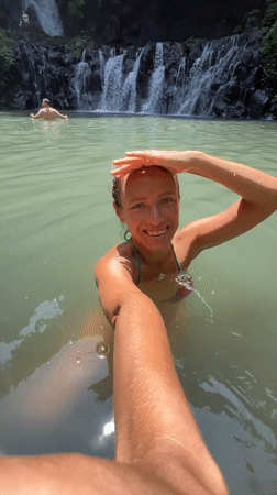 Swimmers enjoy waterfall pool in Susut, Indonesia