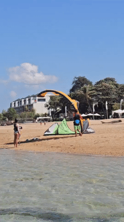 Kitesurfing and beach activity on a Bali morning