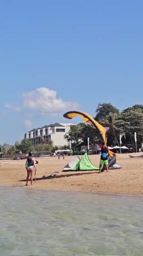 Kitesurfing and beach activity on a Bali morning