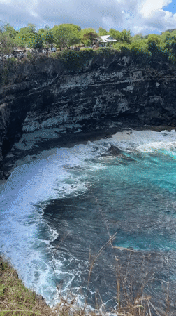 Tourist documents scenic Nusa Penida coastline views in Indonesia
