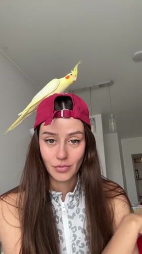 Woman poses with pet cockatiel in Krasnoyarsk home