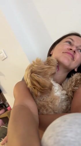 Woman cuddles with small dog indoors in Montenegro