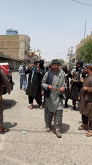 Armed group gathers around police vehicle on Kandahar street