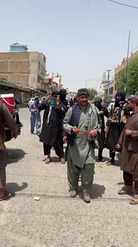 Armed group gathers around police vehicle on Kandahar street
