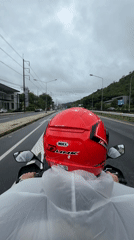 Motorcyclist rides wet roads in Ko Kaeo wearing protective gear
