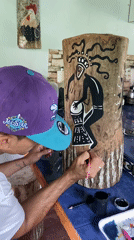 Man paints wooden log in Los Velásquez, Venezuela