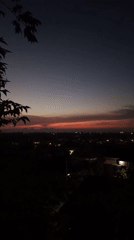 Woman silhouetted against vibrant sunset in Lhokseumawe, Indonesia