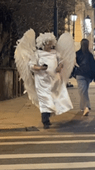 Angel-costumed person crosses Moscow street at night