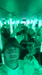 First-person view inside a reflective room with a crowd