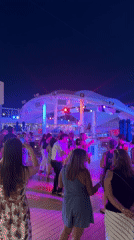 Nighttime deck party in Salobreña with live DJ and colorful lights