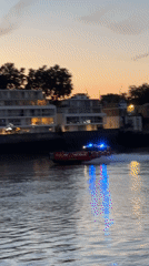 Fire rescue boat speeds along the Thames at dusk