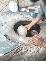 Traditional naan preparation observed at tandoor oven in Pakistan