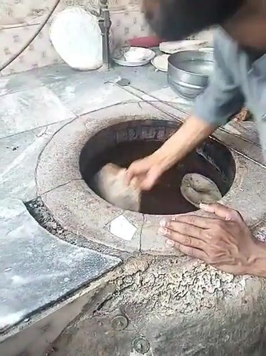 Traditional naan preparation observed at tandoor oven in Pakistan