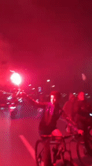 Nighttime street celebration with flags and flares fills Tangier