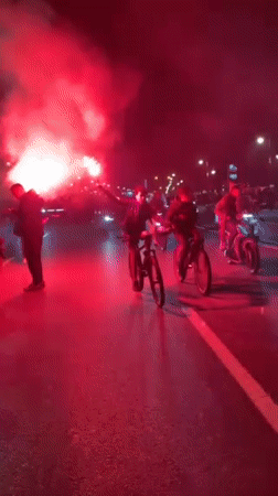 Nighttime street celebration with flags and flares fills Tangier