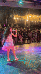Young girl performs at outdoor nighttime show in Porlamar