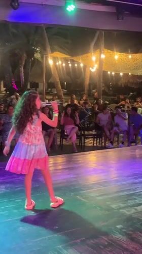 Young girl performs at outdoor nighttime show in Porlamar