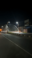 Illuminated white bridge captured at night in Lhokseumawe