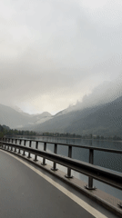 Motorist records overcast Alpine scenery in Le Prese, Switzerland