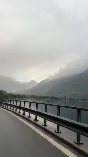 Motorist records overcast Alpine scenery in Le Prese, Switzerland
