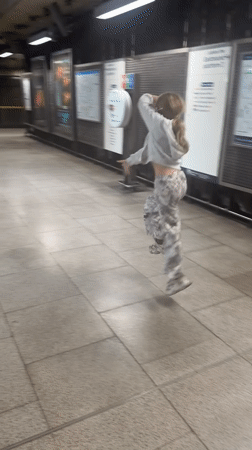 Spinning on a London Underground platform, white hoodie, patterned pants.