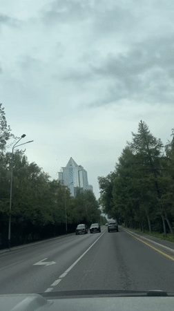 Dashcam-style drive through Almaty traffic with bus in view