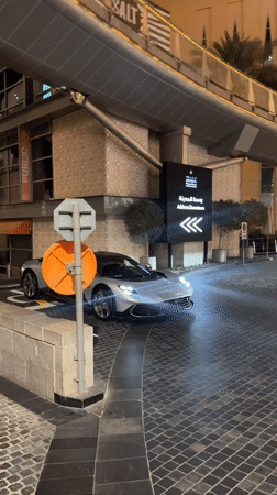 Silver sports car parked on brick driveway in Dubai at night