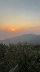 Sunset captured over foggy Đà Nẵng cityscape and mountains