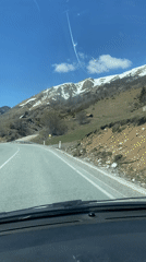 Vehicle travels mountain road in Montenegro on sunny day
