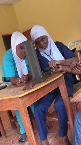 Healthcare workers conduct blood pressure checks in Madangala clinic