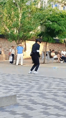 Street dancing in a public plaza near a traditional red building
