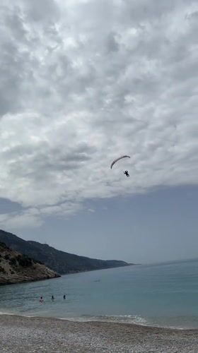 Paraglider descends over busy beach in Fethiye, Turkey