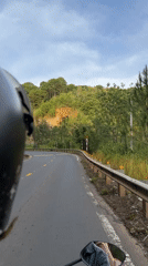 Motorcycle rider travels winding road in rural Vietnam