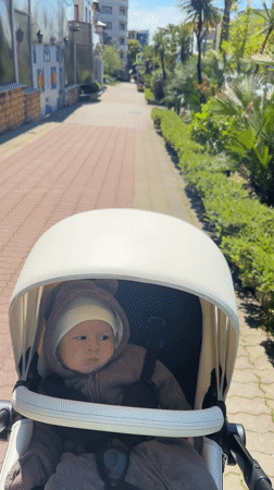 Mother and baby in bear costume enjoy sunny stroll in Sochi