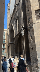 Pedestrians walk near Barcelona Cathedral on narrow street