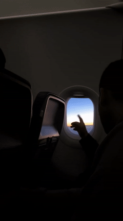 Passenger documents sunrise view from airplane window over Germany