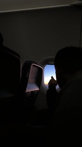 Passenger documents sunrise view from airplane window over Germany