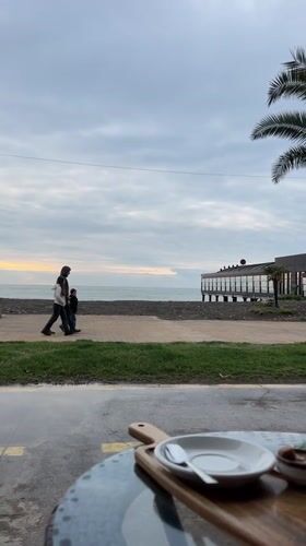 Dog owner enjoys seaside cafe moment in Batumi, Georgia