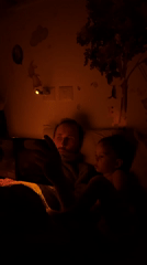 Father reads tablet bedtime story to toddler in Kiryat Bialik