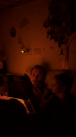 Father reads tablet bedtime story to toddler in Kiryat Bialik