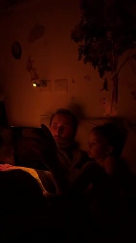 Father reads tablet bedtime story to toddler in Kiryat Bialik