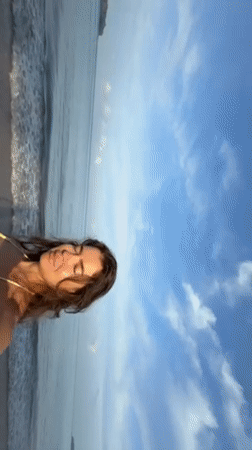 Woman and small dog enjoy beach day in Thailand