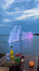 Beer, fried fish, and lit fountains at dusk in Pomorie