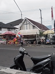 Traditional parade winds through Tawangmangu streets with crowds lining the route