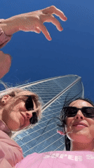Women film selfies near Lakhta Center skyscraper in Saint Petersburg