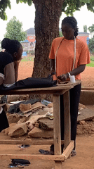 Women work with fabric at outdoor workspace in Nigeria
