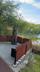 Wooden bear statue overlooks scenic lake in Sovata, Romania