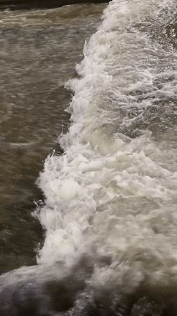 Water flows over dam structure in Almaty, Kazakhstan